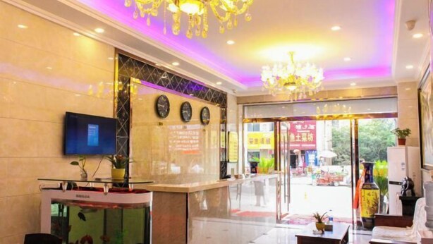 A hotel lobby with a reception desk, a fish tank, and a chandelier. - Yiyoujia Express Hotel (Bengbu)