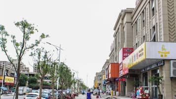 Una calle con edificios, árboles y coches aparcados.