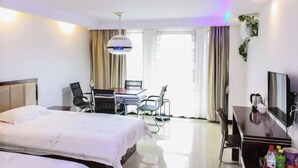A hotel room with a bed, desk, chairs, and a TV. - Yiyoujia Express Hotel (Bengbu)