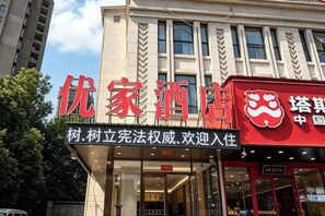 A building with a sign that reads '优家酒店' indicating a hotel.
