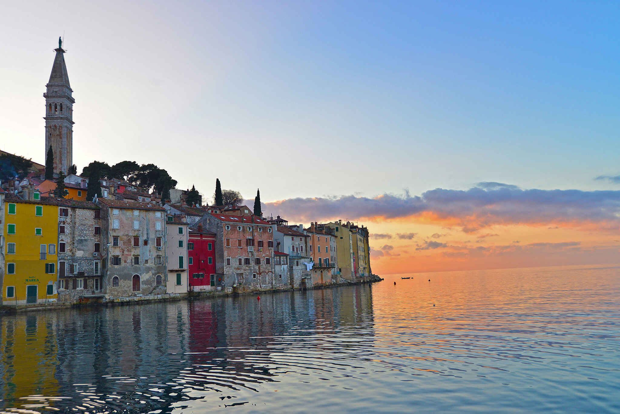 A waterfront cityscape with historic buildings and a prominent tower.