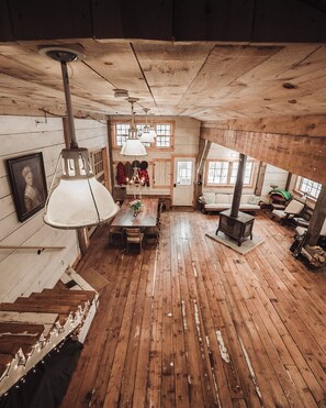 Un interno rustico in legno con un tavolo da pranzo, panche e un camino.