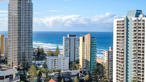 A coastal cityscape with high-rise buildings, a beach, and the ocean.