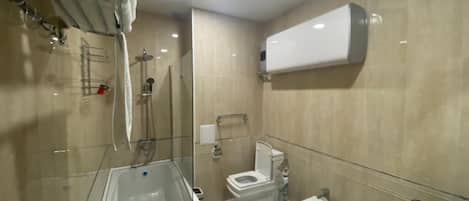 A modern bathroom with a bathtub, toilet, bidet, and sink.