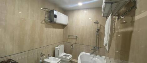 Ein modernes Badezimmer mit Waschbecken, Toilette, Bidet und Badewanne.