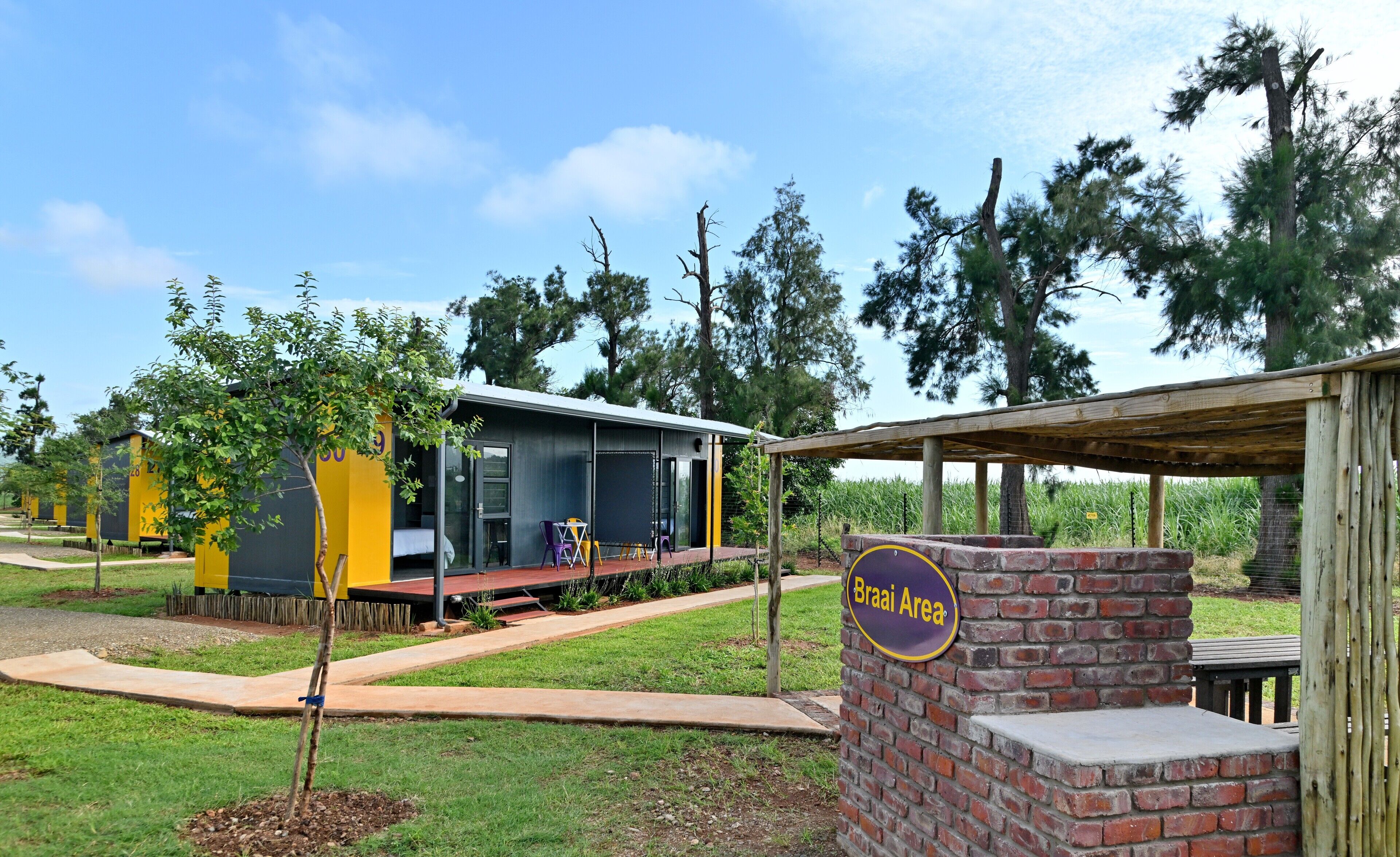 Un edificio moderno con puerta de vidrio y un pequeño espacio al aire libre con mesas y sillas.