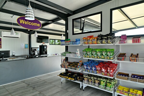 A store interior with shelves stocked with various snacks and a 'Welcome' sign above the counter. - SleepOver Malelane Gate (Nkomazi)
