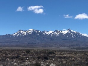 Une chaîne de montagnes aux sommets enneigés, sous un ciel bleu azur.