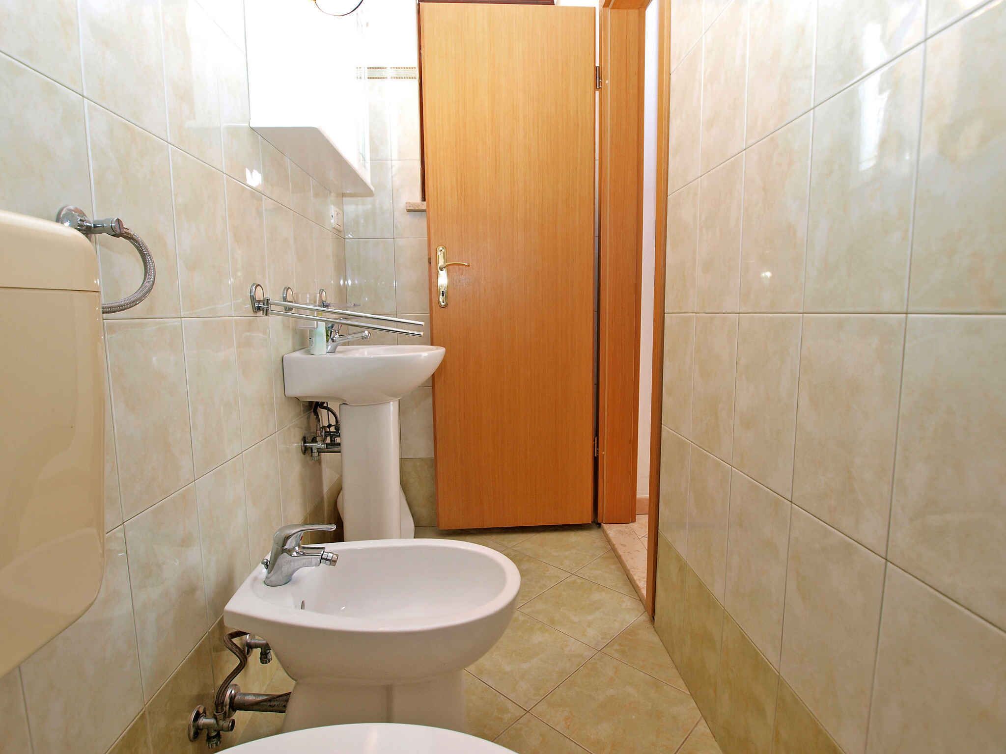 Een badkamer met toilet, bidet en wastafel.