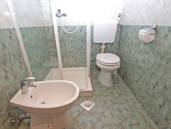 A bathroom with a shower, toilet, and sink.