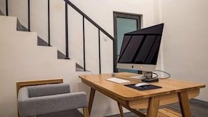A modern office space with a wooden desk, a grey office chair, and a computer monitor. - Wuyishan Yunzhong Jinshu Homestay (Wuyishan)