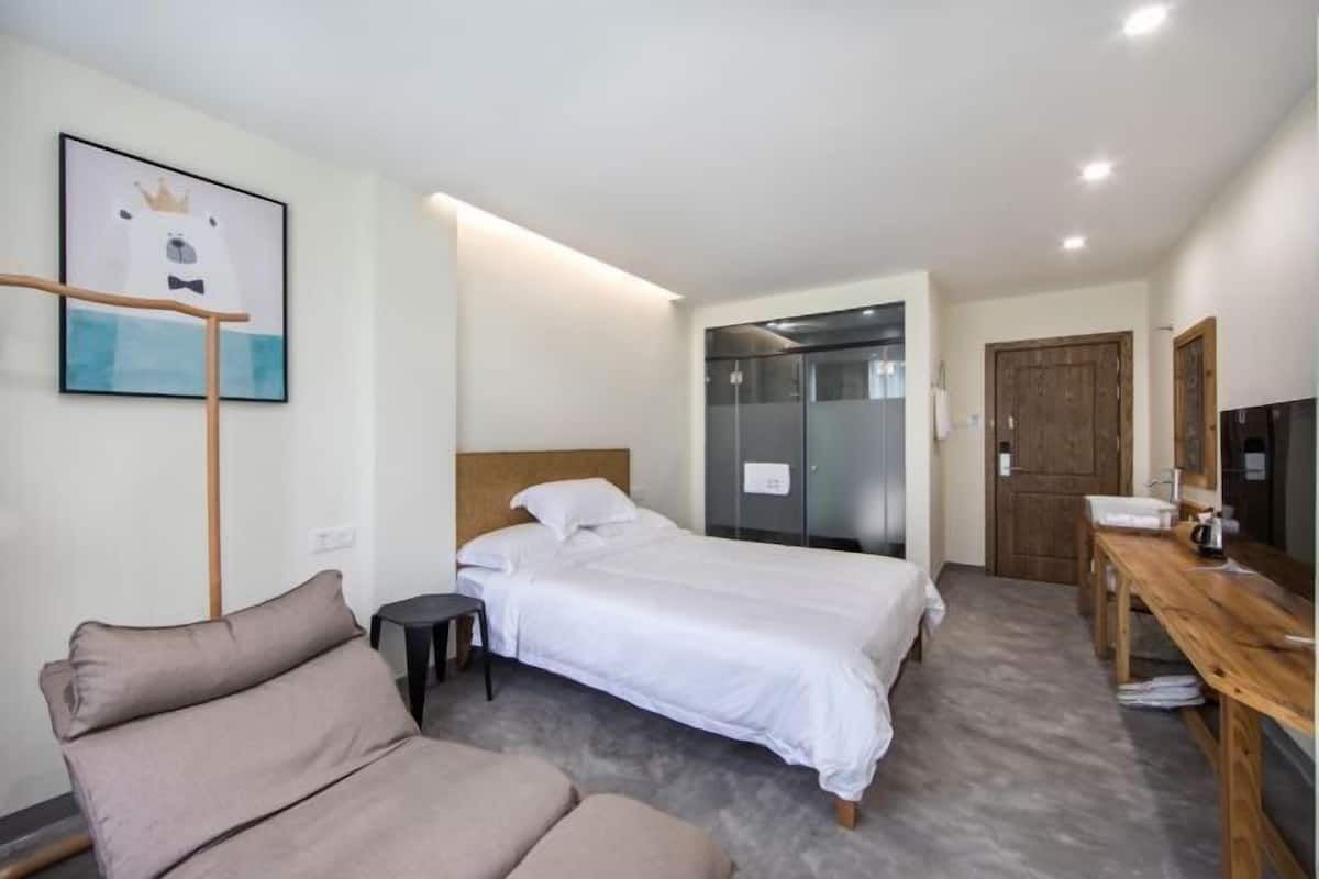 Ein Hotelzimmer mit Bett, Schreibtisch, Stuhl, Kleiderschrank und Bad.