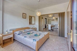 Ein Schlafzimmer mit einem Bett, Nachttischen, einem Spiegel und einer Tür zu einem Badezimmer.