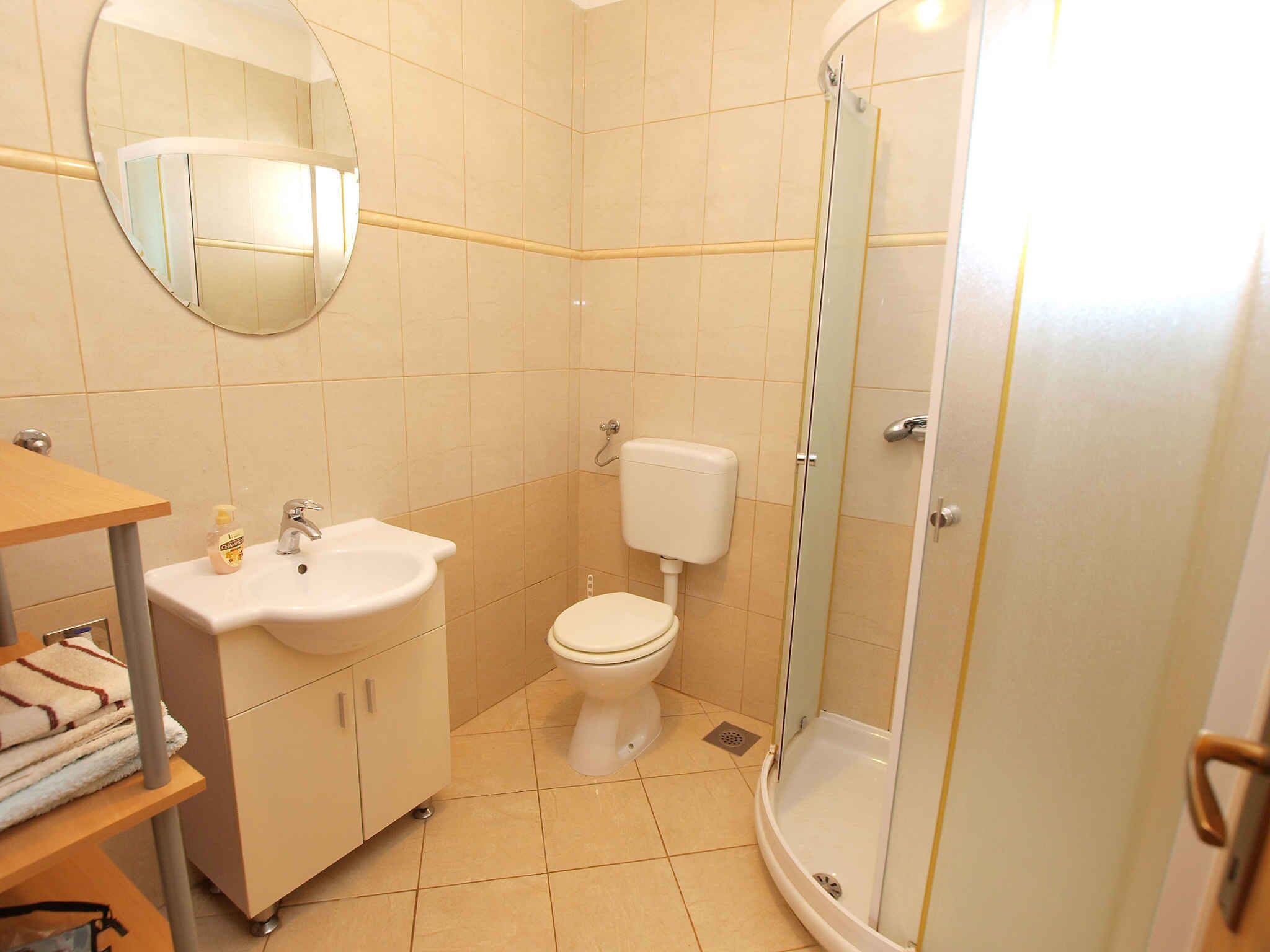 A bathroom with a sink, toilet, and glass-enclosed shower.