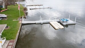 Une jetée s’avançant dans un lac, avec une zone herbeuse et un drapeau sur la gauche.