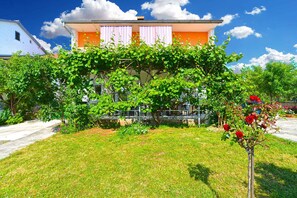 A house with a garden, a pathway, and a clear sky.