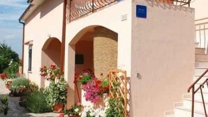 Un immeuble doté d’un balcon, de plantes en pot et d’une antenne parabolique.
