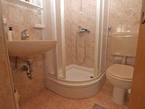 Un bagno con doccia, lavandino e WC.