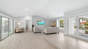 A modern living room with a large TV, a sofa, and a coffee table.