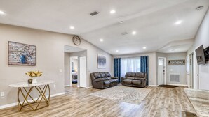A spacious living area with a wooden floor, two leather sofas, a round coffee table, and a painting on the wall. - Relax and recharge Hot Tub,Tesla charger,10 sleeps (Sarasota)