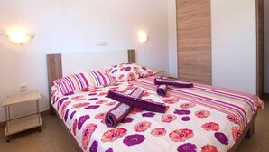 A bedroom with a bed, two bedside tables, and a wooden headboard.