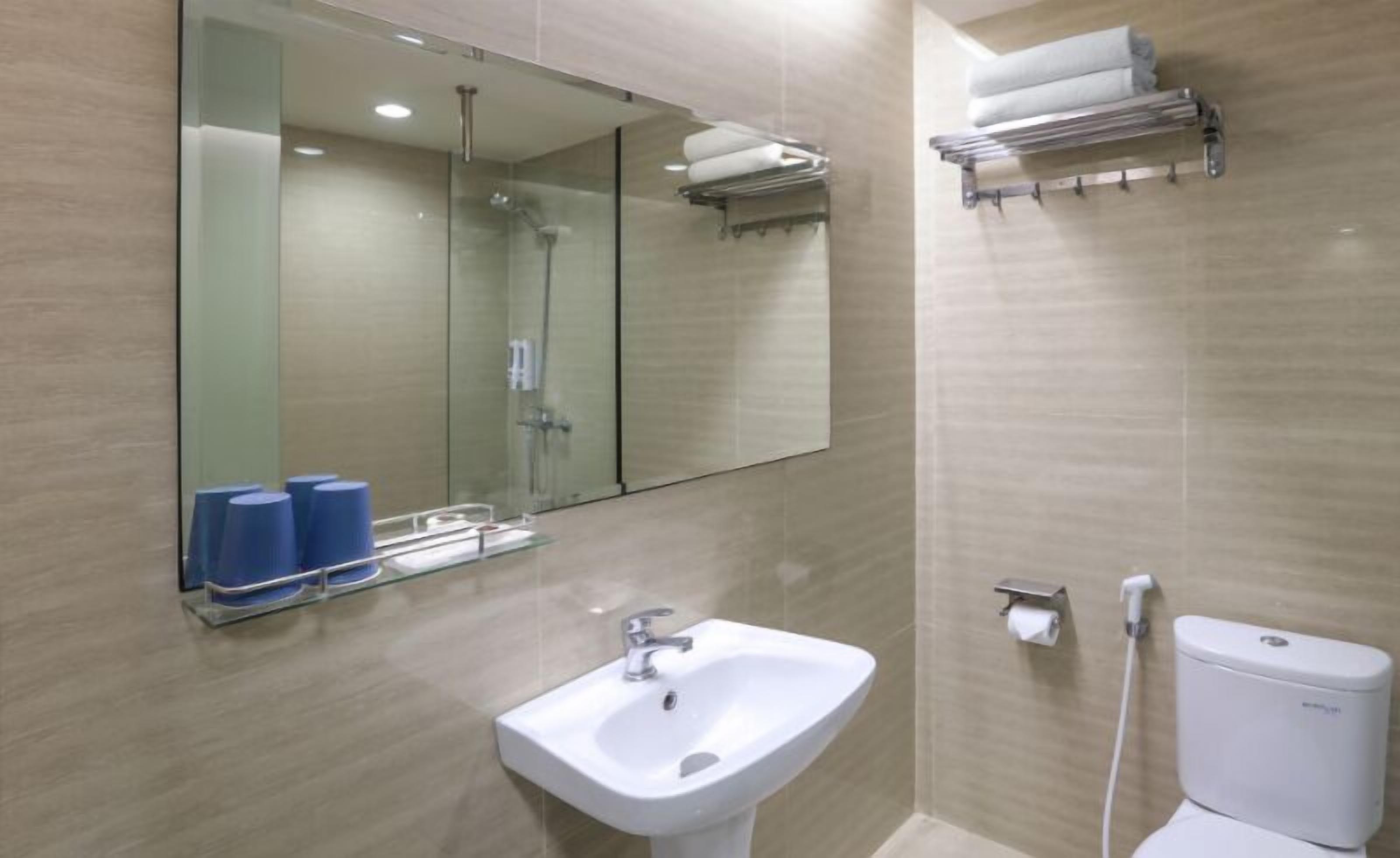 A modern bathroom with a sink, mirror, and toilet.