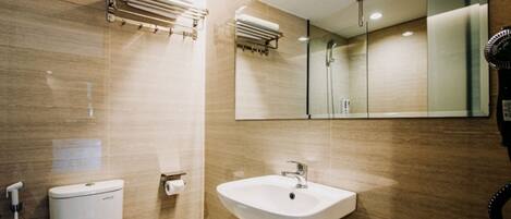 A modern bathroom with a toilet, sink, towel rack, and a mirror.