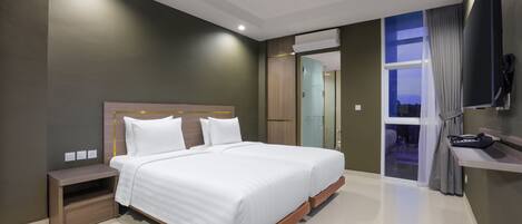 A modern hotel room with a large bed, bedside tables, a TV, and a view of the outside.