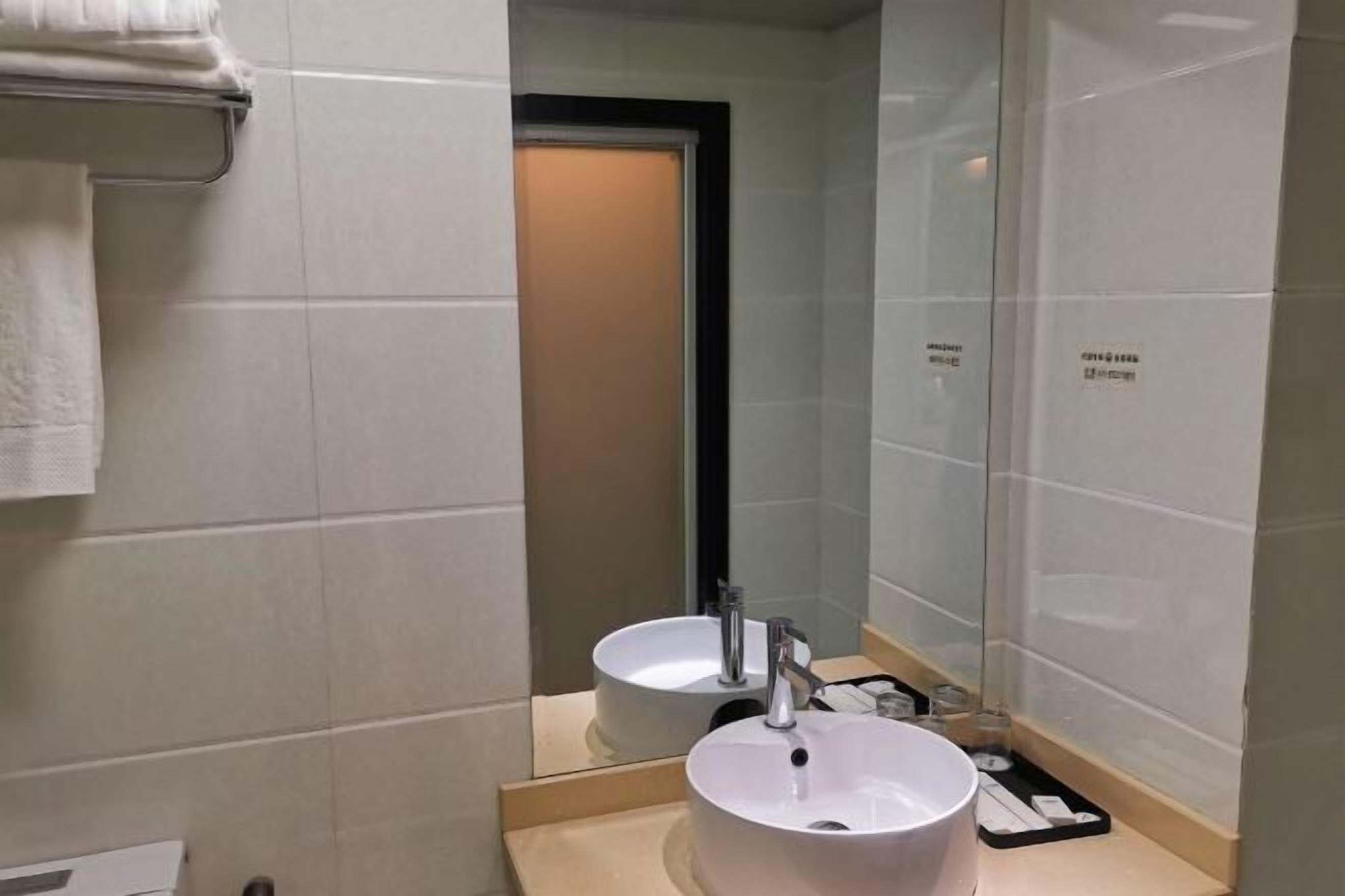 Ein Badezimmer mit Waschbecken, Spiegel und Handtuchhalter.