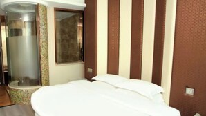 Quarto de hotel com cama, chuveiro e janela.