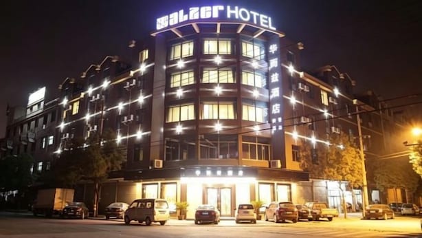 Um hotel com fachada curva, várias janelas e um letreiro no topo.