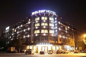 Ett hotell med en böjd fasad, många fönster och en skylt högst upp.
