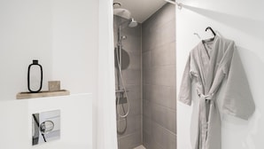 Une salle de bain moderne équipée d’une douche, d’un porte-serviettes et d’un distributeur de serviettes.