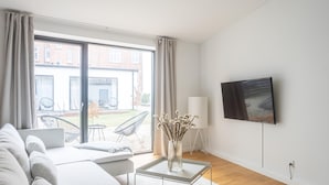 Un salon moderne avec un canapé, une table basse et un téléviseur fixé au mur.