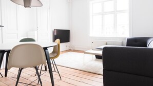 Ein modernes Wohnzimmer mit Essbereich, großem Fenster und Flachbildfernseher.