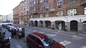 A red car parked on a city street with buildings on both sides. - Nice 1-bed Near Copenhagen Lakes (Copenhagen)