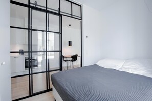 A bedroom with a bed, a desk, and a kitchenette area. - Cool 1-bed w new Yorker Vibes and Private Terrace (Copenhagen)