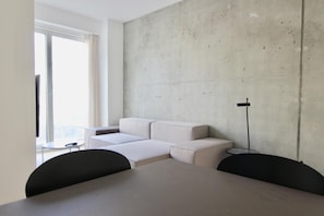 A modern living room with a sectional sofa, a dining table, and chairs. - Cool 1-bed w new Yorker Vibes and Private Terrace (Copenhagen)
