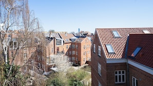 A residential area with brick buildings, some with sloped roofs and skylights, and a clear blue sky. - Beautiful 1-bed in Peaceful Surroundings (Aarhus)