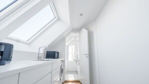 A modern kitchen with skylights, a washing machine, and a sink. - Beautiful 1-bed in Peaceful Surroundings (Aarhus)