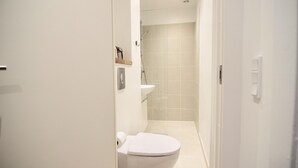 Ein modernes Badezimmer mit Toilette, Waschbecken und Dusche.