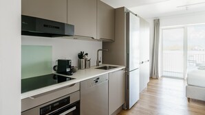 A modern kitchen with stainless steel appliances, a dishwasher, and a large refrigerator.