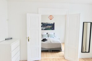 A bedroom with a bed, a dresser, a mirror, and a painting on the wall. - 2-bed Apartment in one of Rhus Best Locations (Aarhus)