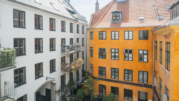 Un patio con edificios que presentan balcones y una mezcla de estilos arquitectónicos.