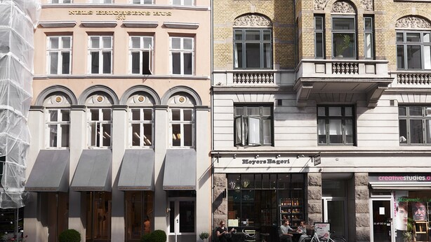 Eine Reihe historischer Gebäude mit unterschiedlichen Baustilen, darunter eine Bäckerei und ein Künstleratelier.