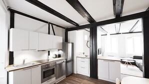 Eine moderne Küche mit weißen Schränken, Edelstahlgeräten und Holzboden.