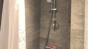 A shower with a handheld showerhead, a vertical rain showerhead, and a handheld shower attachment. - Great Refurbished 2-bed in Amager Island (Copenhagen)