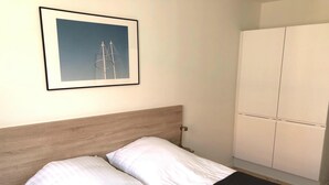 A hotel room with a bed, a framed picture on the wall, and a wardrobe. - Great Refurbished 2-bed in Amager Island (Copenhagen)