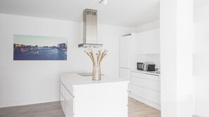 A modern kitchen with white cabinetry, a stainless steel range hood, and a microwave. - Fantastic 1-bed Apartment w Private Terrace (Aarhus)