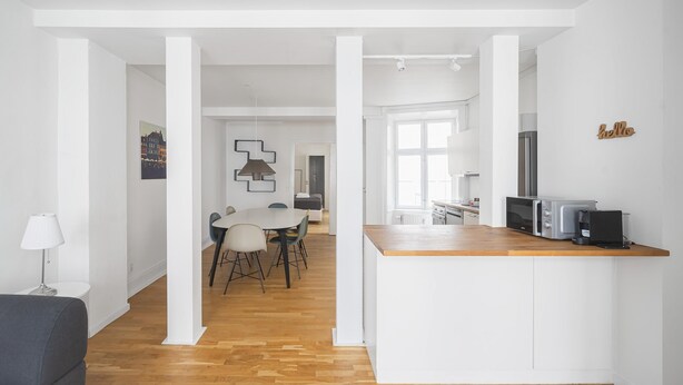 A modern kitchen with white cabinetry, a wooden countertop, and a built-in microwave. - Lovely 2-bedroom Apartment in the Heart of Copenhagen - 62 (Copenhagen)